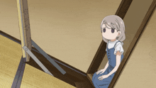 a girl in overalls sits on a set of stairs looking up