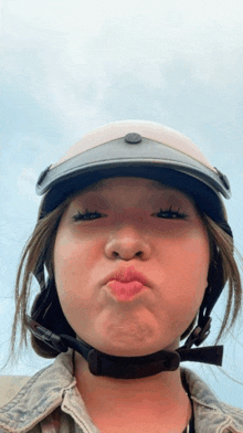a woman wearing a helmet and making a face