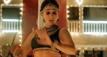 a woman in a black top is dancing in a room with lights on .