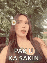 a woman with a flower in her hair and the words `` pak u ka sakin '' written on her face .