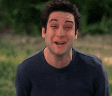 a man in a blue shirt is laughing with his tongue sticking out