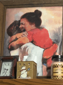 a picture of a woman hugging a man next to a jar of candle wax