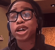 a young man wearing glasses and headphones is making a funny face
