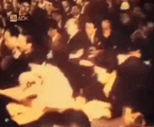 a crowd of people are gathered in front of a screen that says 24 ack on it