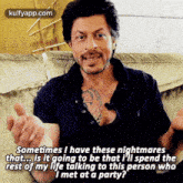 a man with a tattoo on his chest is sitting on a couch and talking to another man .