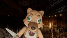 a stuffed animal with green eyes is holding scissors