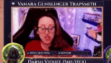 a woman wearing glasses and a red shirt is sitting in front of a computer monitor .