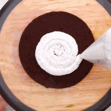 a chocolate cake with whipped cream being poured on it