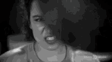 a black and white photo of a woman with an angry look on her face