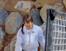 a girl in a white jacket with the letter l on it