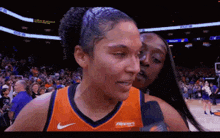 two female basketball players are talking to each other on a court