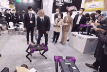 a group of people are looking at a robot that says minirobot on it