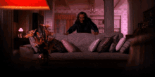 a man sitting on a couch in a living room with a lamp in the background