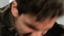 a close up of a man 's face with his eyes closed and his hair blowing in the wind .