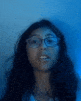 a young girl wearing glasses looks at the camera