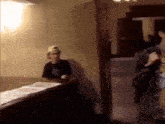 a blurry picture of a man wearing a hat sitting at a table