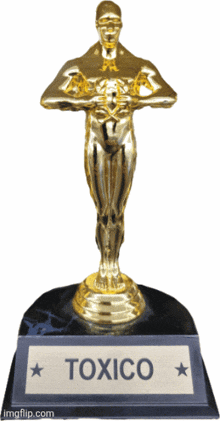 a gold statue with the word toxico on the bottom