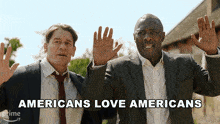 two men in suits are standing next to each other with the words americans love americans behind them