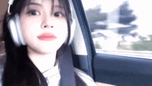 a young woman wearing headphones is sitting in a car .