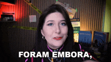 a woman says " foram embora " in front of a metal wall