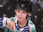 a woman wearing a headband with a cross on it is giving a thumbs up .