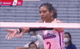 a woman is playing volleyball on a court while wearing a teamline jersey .