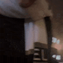 a blurry picture of a person standing in a dark room .