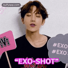 a man is holding a sign that says `` exo shot '' .