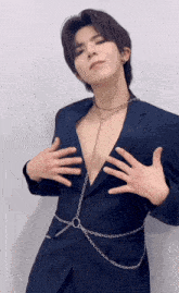 a man in a suit has chains around his waist and chest