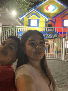 a couple posing for a picture in front of a building that says ' yc ' on it