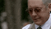 a close up of a man wearing sunglasses and a tie