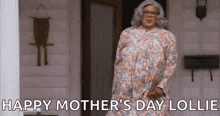 a woman in a dress is standing on a porch and says `` happy mother 's day lollie '' .