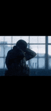 a man is standing in front of a window looking out .