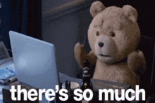 a teddy bear sitting in front of a laptop with the words there 's so much above him