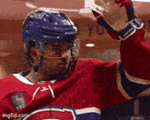 a hockey player wearing a bell helmet and a red white and blue jersey