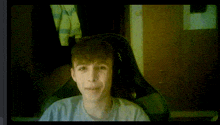 a young man is sitting in a chair with the letter m on the back
