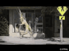 a gif of a person walking down a street with a crosswalk sign