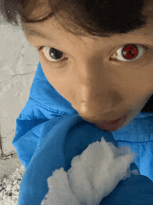 a close up of a person 's face with red eyes and a blue jacket