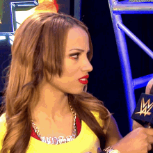 a woman wearing a yellow shirt that has the word sasha on it