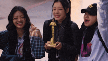a girl in a la hat holds a statue of a man