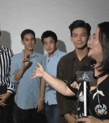 a woman is talking to a group of young men while standing in front of a microphone that says alpine world