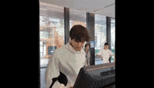 a man is standing in front of a treadmill in a gym .