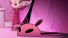 a pair of pink bunny slippers are sitting on a purple surface