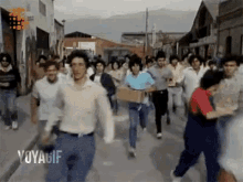 a group of people are running down a street with the words yoyagif on the bottom