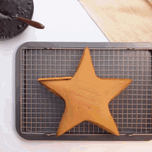 a star shaped cake is sitting on a wire rack