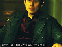 a man wearing a green jacket and a red vest has asian writing on the bottom right