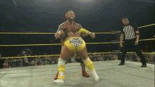 a wrestler wearing yellow shorts that say young