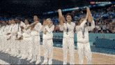 a group of female athletes are holding up their medals in front of a crowd in a stadium that says eurosport live