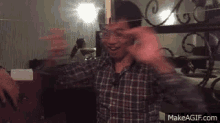 a man in a plaid shirt is standing in front of a mirror .