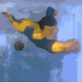 a man is swimming in a pool with a ball